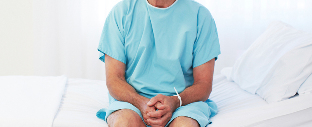 Ein Mann sitzt in einem Krankenhausbett